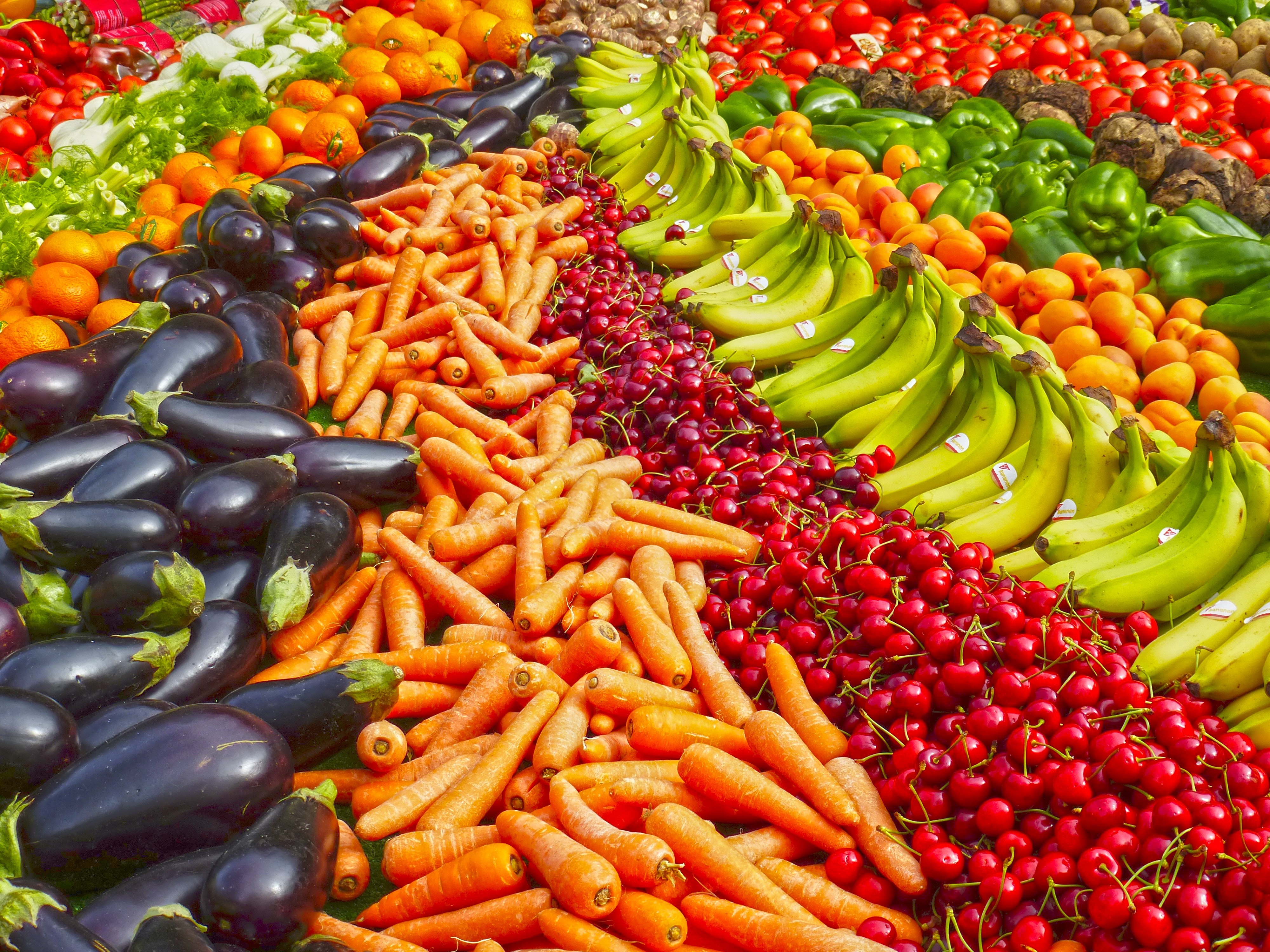 Imagem com filas de legumes na vertical: berinjelas, cenouras, cerejas, bananas, pessegos, pepinos, tomates..